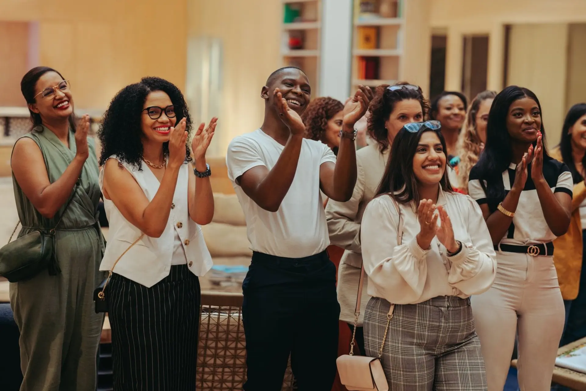 A diverse group of people clapping and smiling